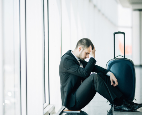 Business person with suitcase in airport stressed
